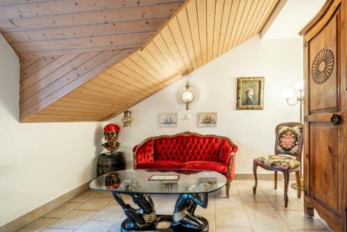 a living room with a red couch and a table at Altstadt Hotel Magic Luzern in Luzern