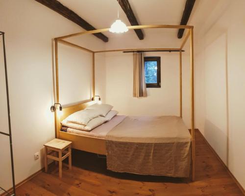 1 dormitorio con cama con dosel y ventana en Tepke Guesthouse Garáb, en Garáb