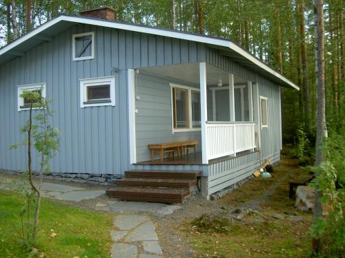 a blue tiny house in the woods at Kuus-Hukkala in Harkala