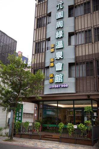 a building with a sign on the side of it at π 園周綠溫泉會館-泉鄉雅舍 in Jiaoxi