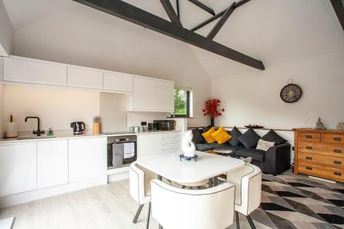 a kitchen and living room with a table and a couch at Luxury retreat 32c pool jacuzzi games bar oasis in Deal