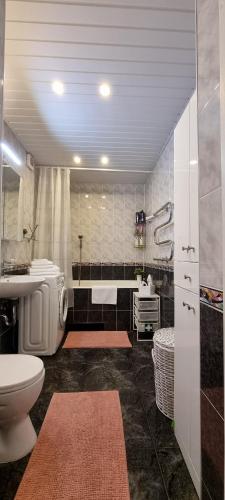 łazienka z toaletą, umywalką i wanną w obiekcie Santariškės Apartment w Wilnie