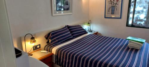 サン・ルイス・デ・サビニリャスにあるRio Manilvaのベッドルーム1室(青と白のストライプの毛布付きのベッド1台付)