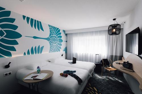 a hotel room with a large bed and a desk at ibis Styles Nancy Laxou in Nancy