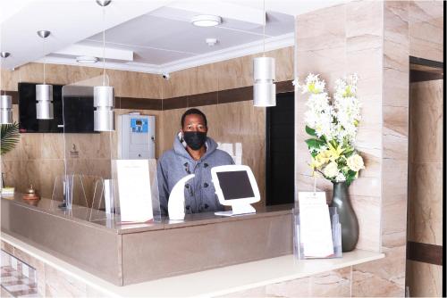 a man standing behind a counter in a mirror at Eagle Nest Luxury Accommodation in Roodepoort