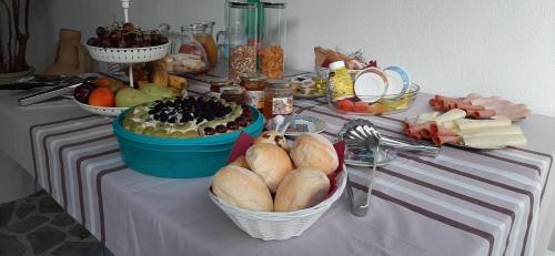 a table topped with baskets of bread and other foods at La Vecchia Dimora in Marrùbiu