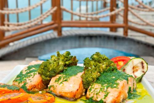 a plate of food with broccoli and chicken and vegetables at Pontalmar Praia Hotel in Natal