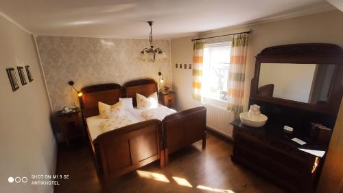 um quarto com uma cama com almofadas brancas e um espelho em Antikhotel Steinbacher Hof em Steinbach am Wald
