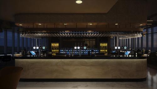 a bar in a restaurant with wine glasses at Hotel La Tour in Milton Keynes