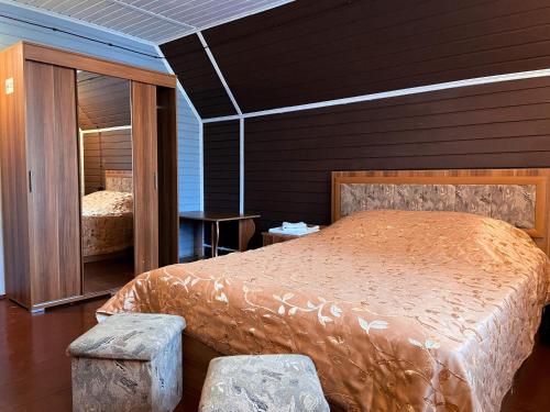 - une chambre avec un lit et un miroir dans l'établissement Lesnaya Skazka Hotel, à Pereslavl-Zalesski