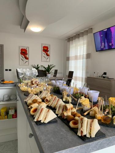 a buffet with sandwiches and pastries on a table at Gioema in Borgo Vodice