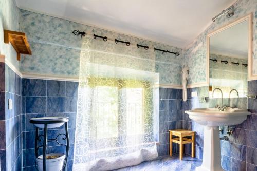 ein Bad mit einem Waschbecken und einem Fenster in der Unterkunft Poggio Agli Ulivi in Barberino di Mugello