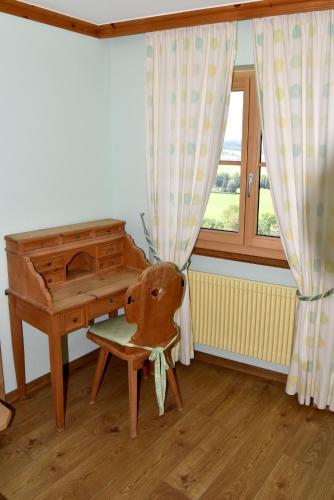 a wooden chair sitting in front of a piano at Hôtel de Ville in Gruyères