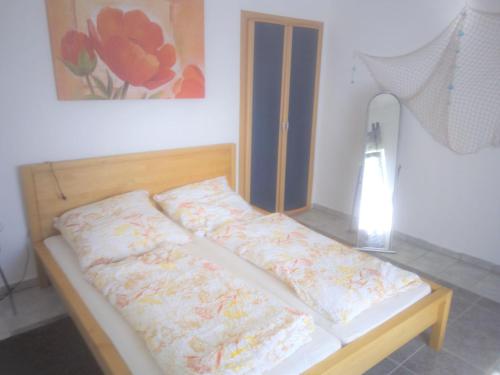 uma cama com duas almofadas num quarto em Ferienhaus-Poweleit em Börgerende-Rethwisch