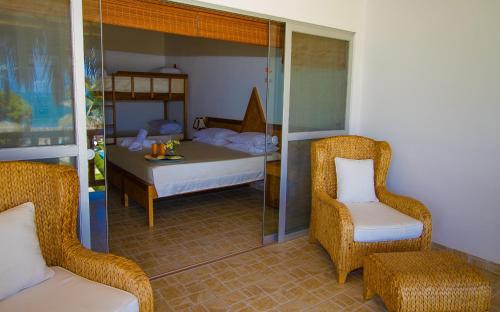 une chambre avec un lit, une chaise et une table dans l'établissement Hotel Casa Mediterranea Mancora, à Máncora