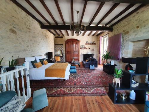a bedroom with a bed and a living room at Le Mas Réolais in Saint-Sève