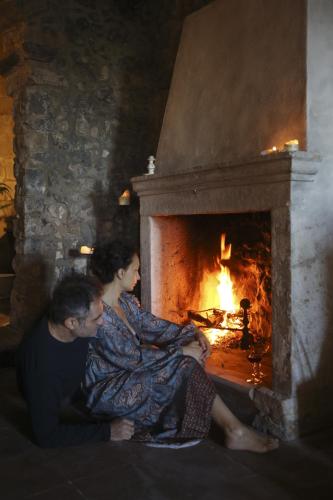 a man and a woman sitting in front of a fireplace at Casa Aulivo in Caiazzo