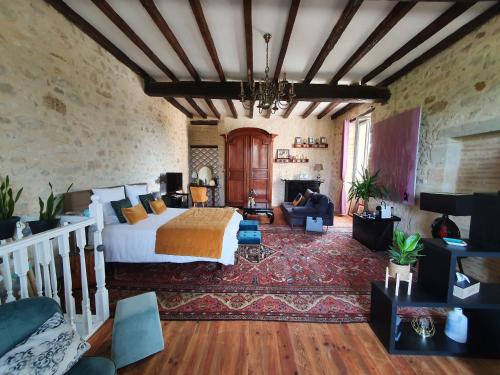 a bedroom with a bed and a living room at Le Mas Réolais in Saint-Sève