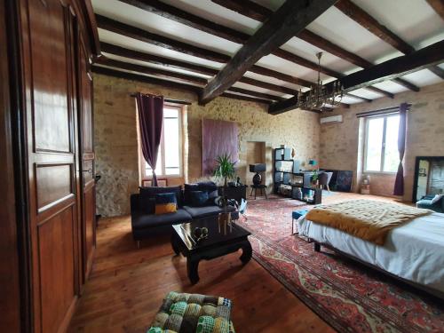 a large room with a bed and a couch at Le Mas Réolais in Saint-Sève