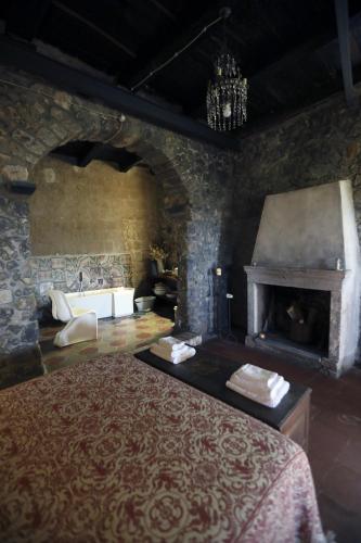 a stone room with a bed and a fireplace at Casa Aulivo in Caiazzo