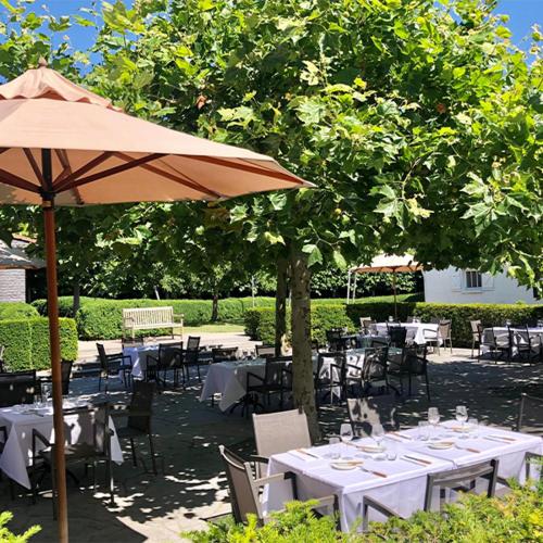 a group of tables and chairs with an umbrella at Hostellerie Klokhof in Kortrijk