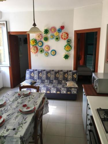 sala de estar con mesa y sofá con flores en la pared en APPARTAMENTO MICHELE, en Ventimiglia