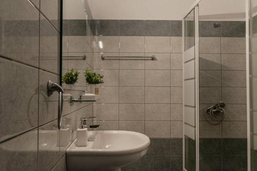 a bathroom with a sink and a glass shower at Aigli's Urban Lodge in Volos