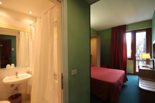 a bathroom with a sink and a bed in a room at Hotel Meridiana in Florence