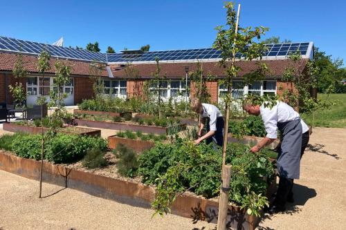 two people working in a garden in front of a building at Best Western Hotel Hillerød in Hillerød
