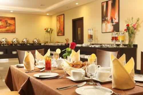 a table with plates and napkins on top at Best Western Plus Salmiya in Kuwait