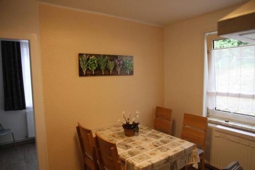 a dining room with a table with chairs and a painting on the wall at Wohnung Julius 3 in Sankt Andreasberg