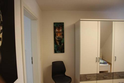 a room with a chair and a painting of a tiger at Wohnung Julius 3 in Sankt Andreasberg