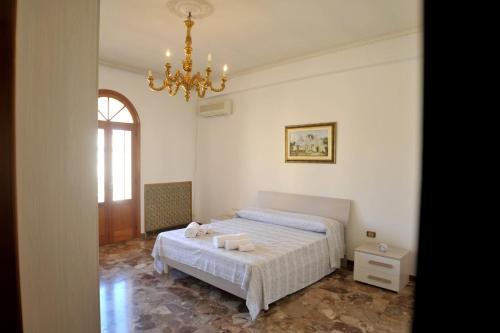 um quarto com uma cama e um lustre em AL CASTELLO Appartamenti em Torricella