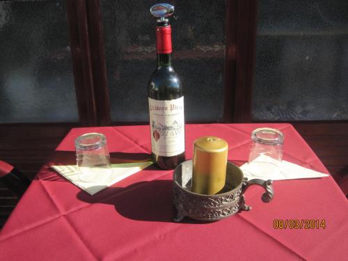 a bottle of wine sitting on top of a red table at Hotel Le Commerce in Neuville