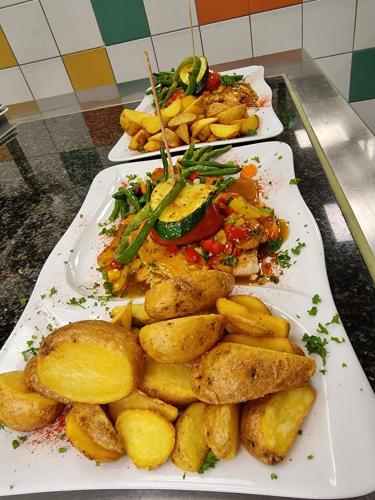 two plates of food on a table with potatoes at Haiminger Hof in Haiming