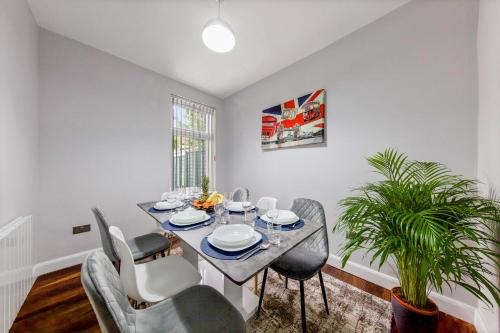 un comedor con mesa, sillas y una planta en Stunning house, en Londres