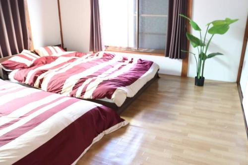 a bed in a bedroom with a wooden floor at リテックス浦安 in Tokyo