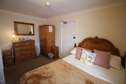 1 dormitorio con 1 cama grande y vestidor en Springwell Inn, en Pendine