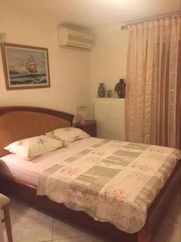 a bedroom with a bed with a quilt on it at Siga Siga Apartment in Megara