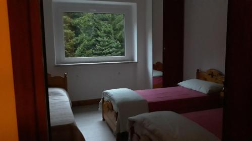 a room with two beds and a window at Casa vacanza Terry a Sella Nevea in Sella Nevea