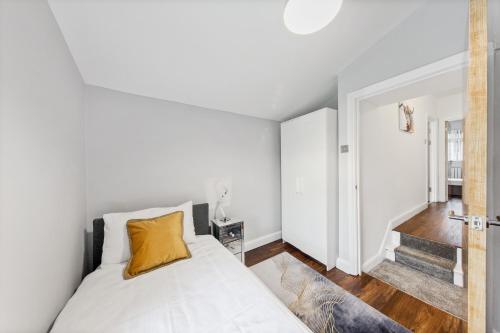 a white bedroom with a bed and a staircase at Stunning house in London