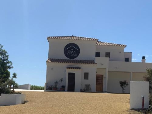 Ein weißes Gebäude mit einem schwarzen Schild drauf. in der Unterkunft Casa Bédar in Bédar