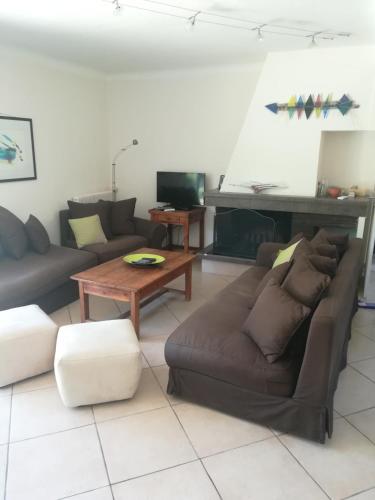 - un salon avec des canapés, une table et un piano dans l'établissement La Treize, à Laroque-des-Albères