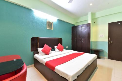 a bedroom with a bed with red pillows on it at Hotel Moon Sky Ajmer in Ajmer