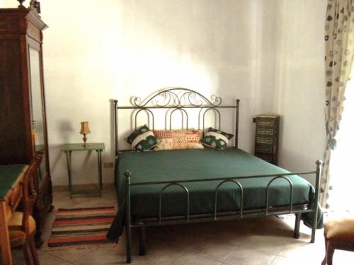 a bedroom with a green bed in a room at Agriturismo S.Lucia in Roccaforte Mondovì
