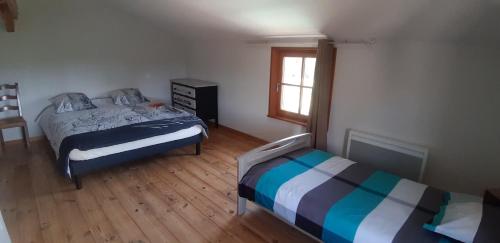 a bedroom with two beds and a window at La ferme du Bouton d'Or in Vendranges