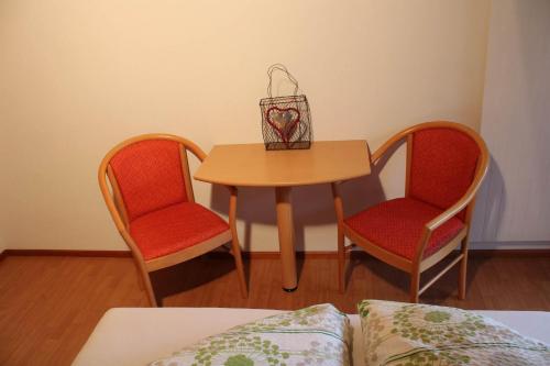 a table with two chairs and a table with a heart basket on it at Bergjuwel in Schruns-Tschagguns