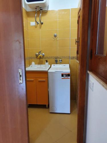 uma pequena casa de banho com um lavatório e uma máquina de lavar roupa em Appartamento Ionios em Noto Marina