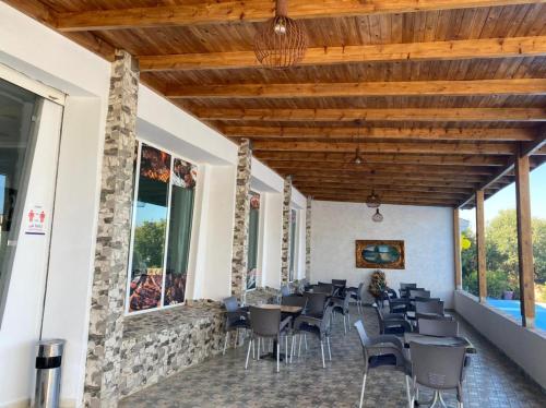 um restaurante com cadeiras, mesas e janelas em La Perle De Briech em Asilah