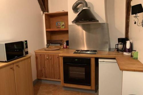 Il comprend une cuisine équipée d'une cuisinière. - un four à micro-ondes dans l'établissement Appartement entre Paris et CDG, à Écouen